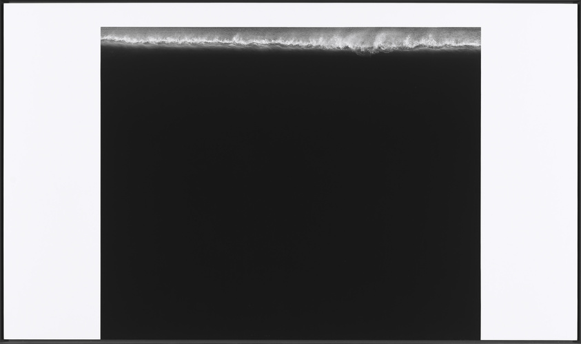 Monochrome image of a wave cresting, bordered by white frame, evoking a sense of calm and simplicity.