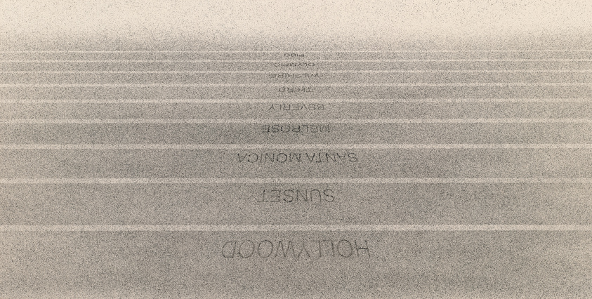 Grainy image of text with varying visibility, some words reversed, creating an abstract pattern on a textured background.