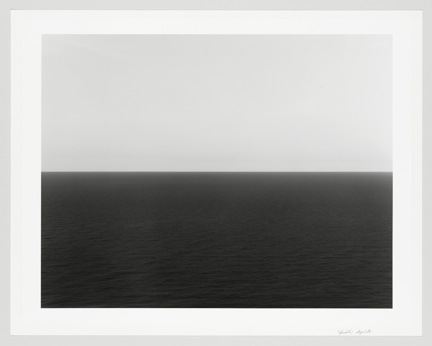 A minimalist seascape with a calm ocean and overcast sky, framed and signed on the bottom right.