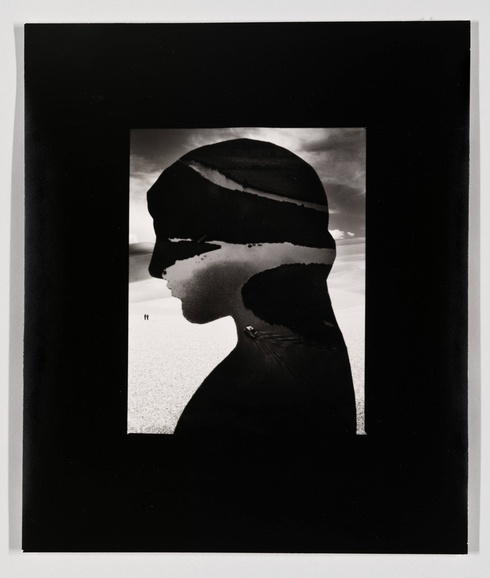 A black and white artistic photograph featuring a silhouette of a person's profile overlaid on a landscape scene, creating a double exposure effect. The landscape appears to be a desert with a vast, open sky and two tiny figures visible in the distance, suggesting a sense of scale and solitude. The silhouette's edges are rough and textured, blending seamlessly with the terrain. The image is framed with a black border, enhancing its dramatic contrast.