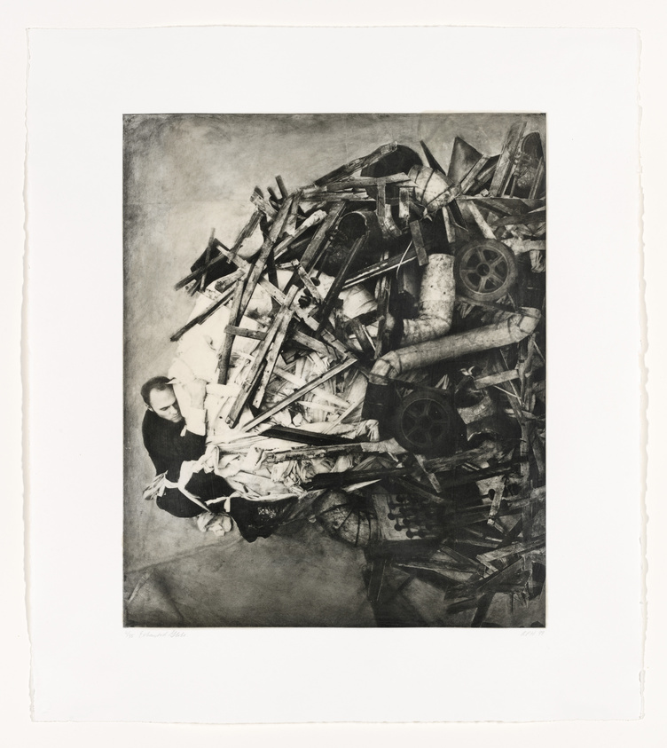 A black and white artwork depicting a person partially buried under a large pile of debris, including wooden planks, wheels, and unidentifiable rubble. The individual appears calm and is gazing directly at the viewer, creating a stark contrast with the chaos of the surrounding wreckage. The image has a rough texture and is bordered by a white margin with the artist's signature at the bottom left corner.