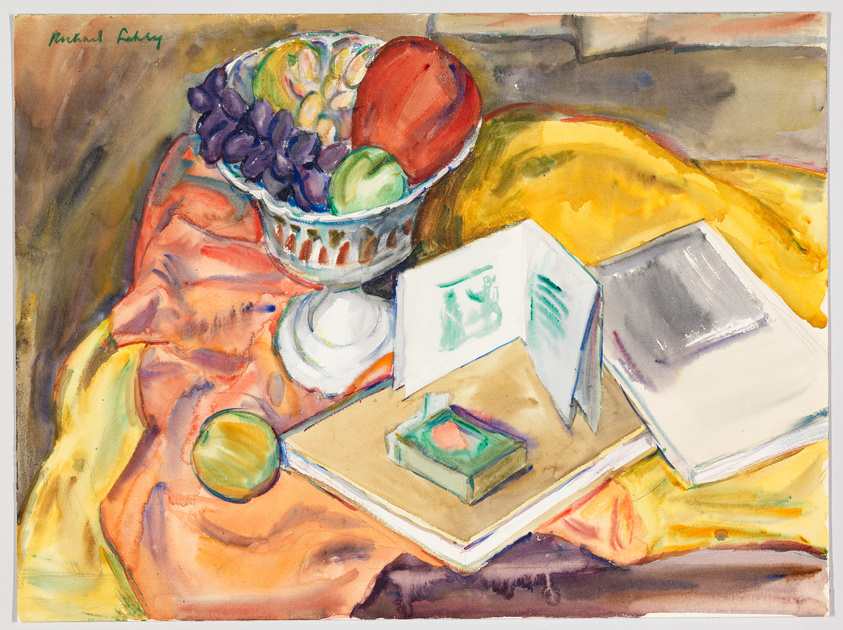 A vibrant watercolor still life painting featuring a bowl of fruit, including grapes and a large red apple, on a draped fabric with a pattern of warm colors. Beside the fruit bowl, there are open books with visible text and illustrations, a green apple, and a small box on top of the books. The artist's signature is visible in the top left corner. The background suggests a tabletop against a neutral wall.