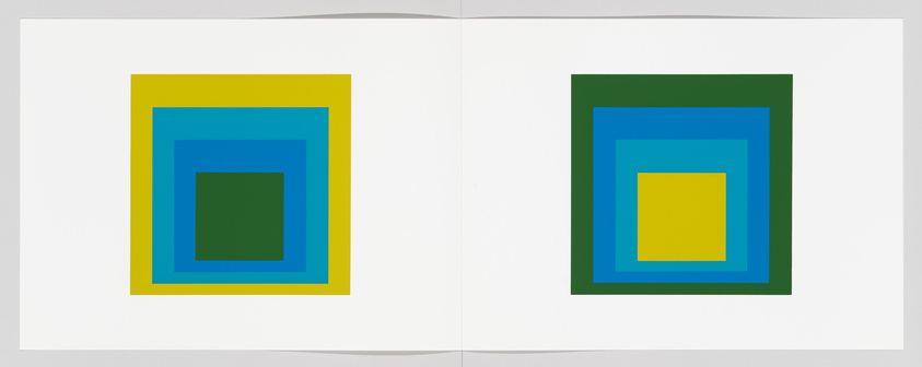 Concentric squares in blue, green, and yellow on an open book, with mirrored layouts on each page.