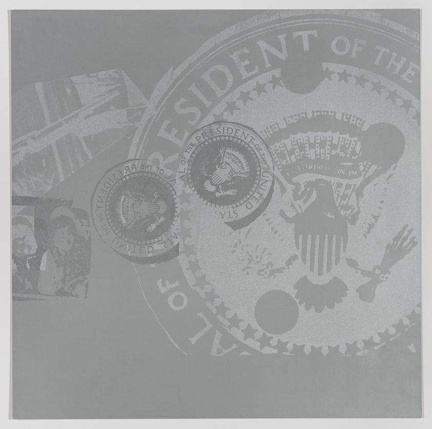 A grayscale image featuring various embossed seals and insignia related to the President of the United States, with the most prominent being the Presidential Seal in the center. The image has a textured appearance with subtle variations in shades of gray, creating a monochromatic and official-looking design.