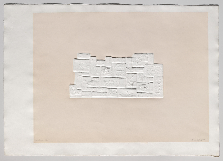 A textured white relief artwork composed of various geometric and abstract shapes on a beige paper background, with the artist's signature at the bottom right corner. The paper has rough edges, suggesting it may be hand-torn or specially crafted.