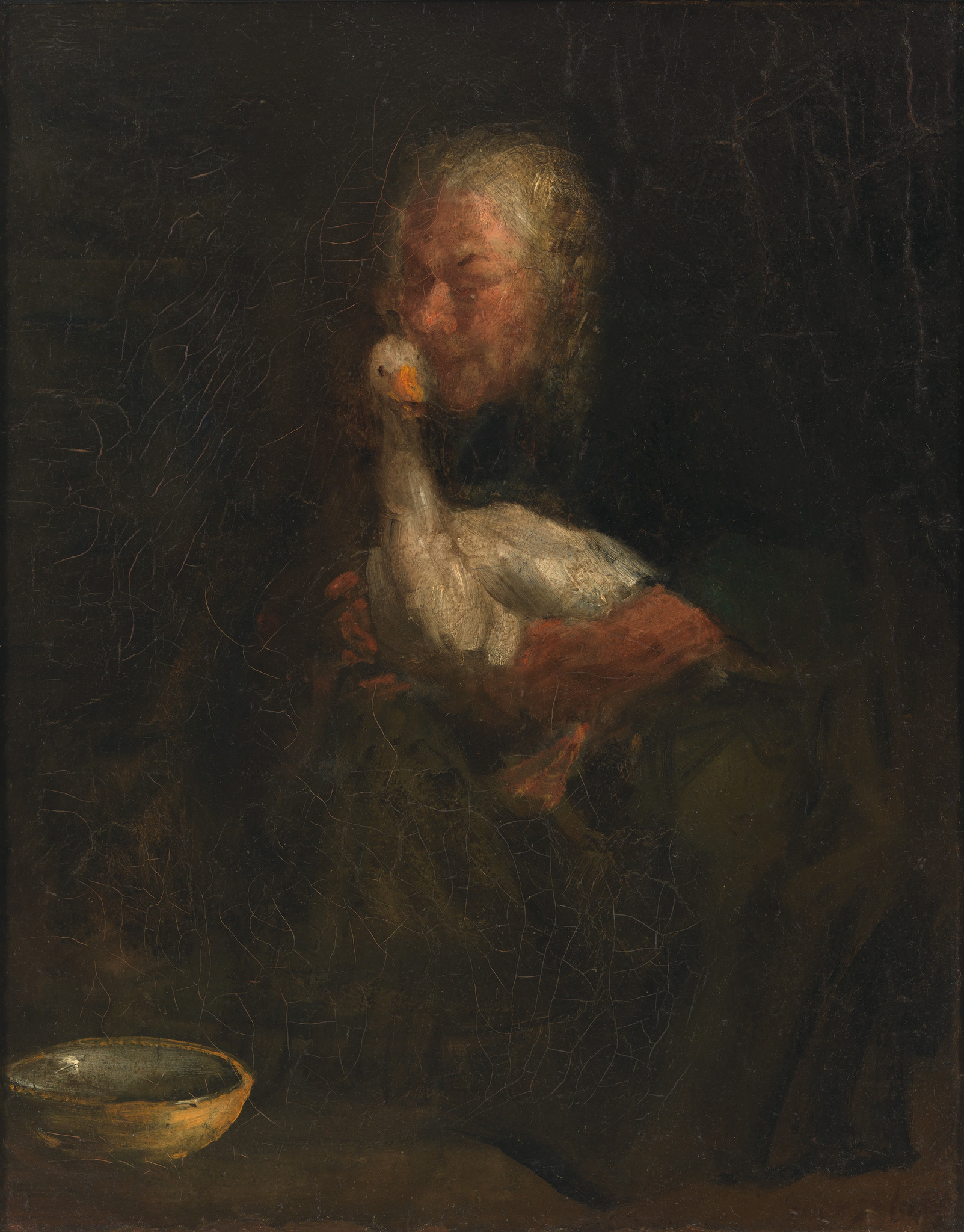 Person holding a white goose closely, with a small bowl nearby on a dark background.