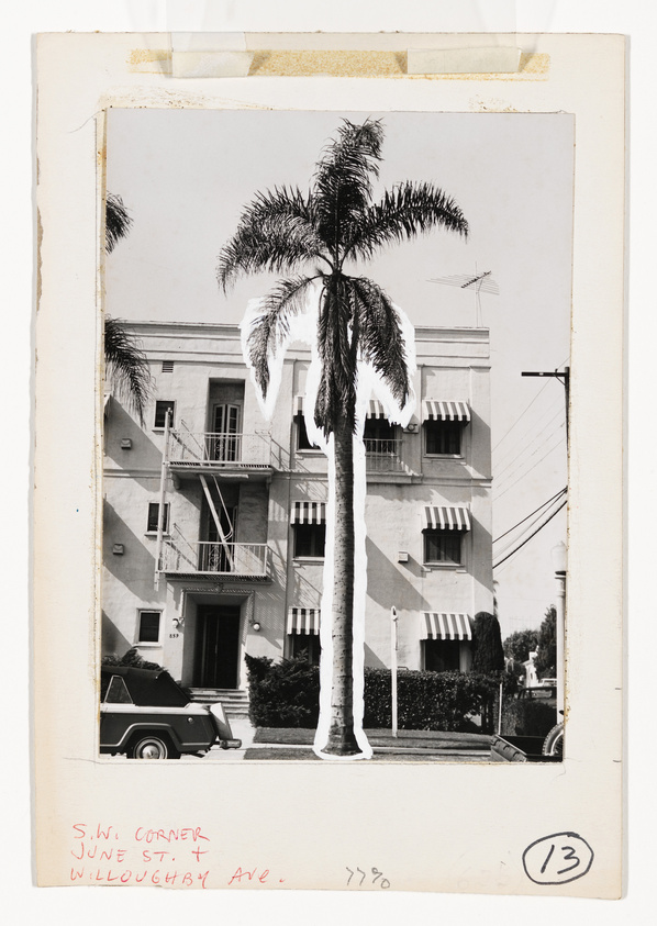A vintage black and white photograph depicting a three-story building with striped awnings over the windows and a palm tree in the foreground. There is a classic car parked on the street corner, and handwritten text at the bottom indicates the location as the southwest corner of June St. and Willoughby Ave. The photo has a white border with signs of age and wear, and the number 13 is stamped in a circle at the bottom right.