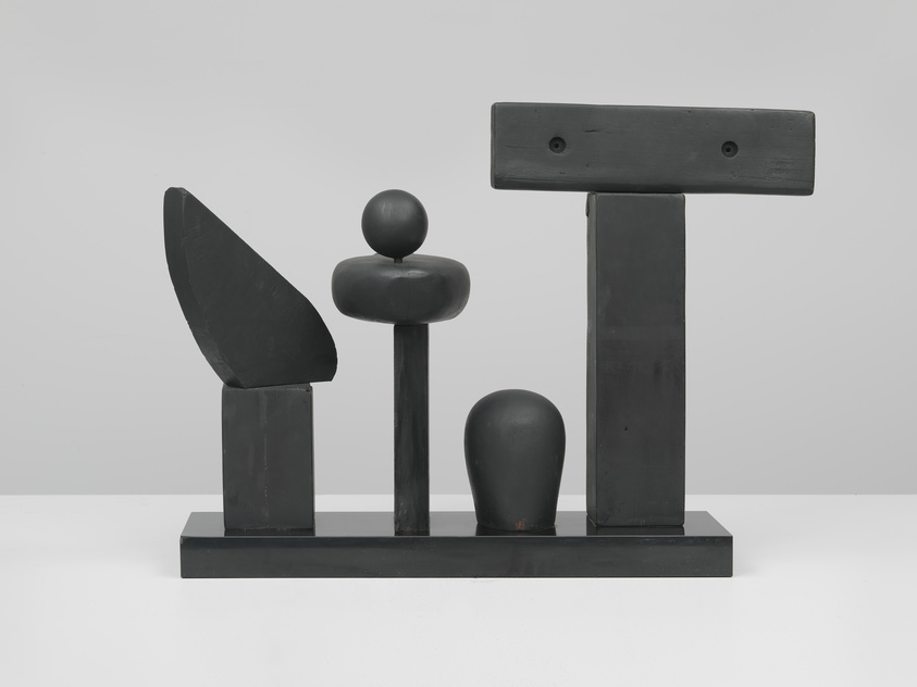 Abstract black sculpture with geometric shapes on a rectangular base, including spheres and rectangles.