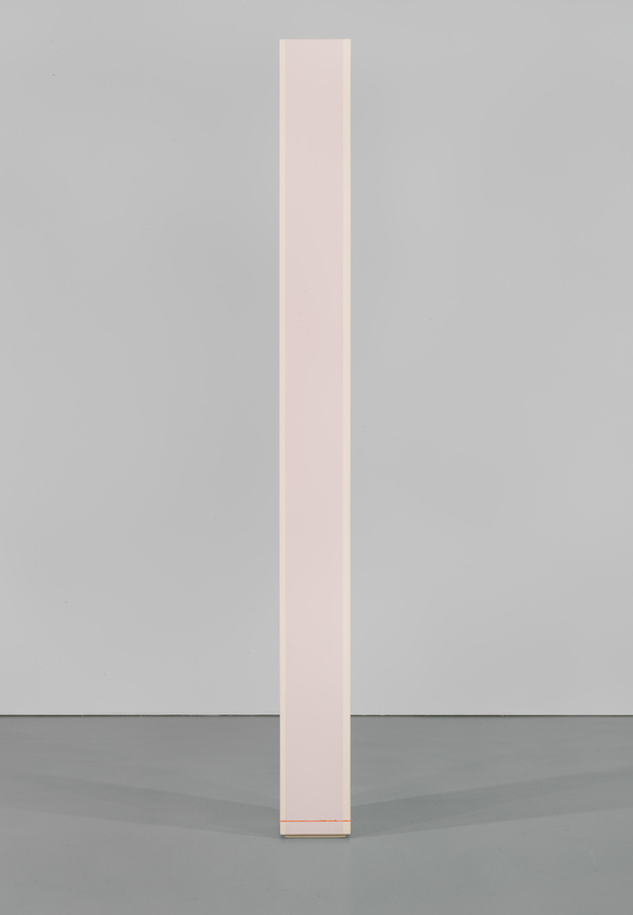 Tall, narrow, white rectangular column standing upright on a gray floor against a gray background.