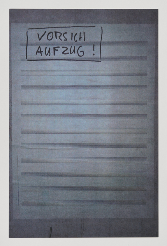 A handwritten sign with the words "VORSICHT AUFZUG!" which translates to "CAUTION ELEVATOR!" in German, written in black marker on a lined piece of paper that appears to be taped to a surface. The background is a muted blue-gray tone.
