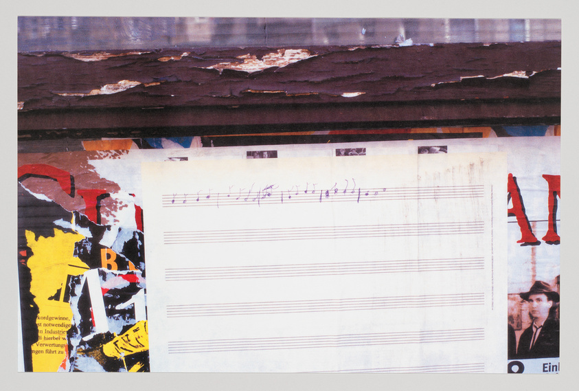 A collage of various elements including torn posters with text and images, a piece of sheet music with handwritten notes, and a weathered wooden surface at the top. The posters feature bold colors like red and yellow, and there's a small photo of a person's face in the bottom right corner.