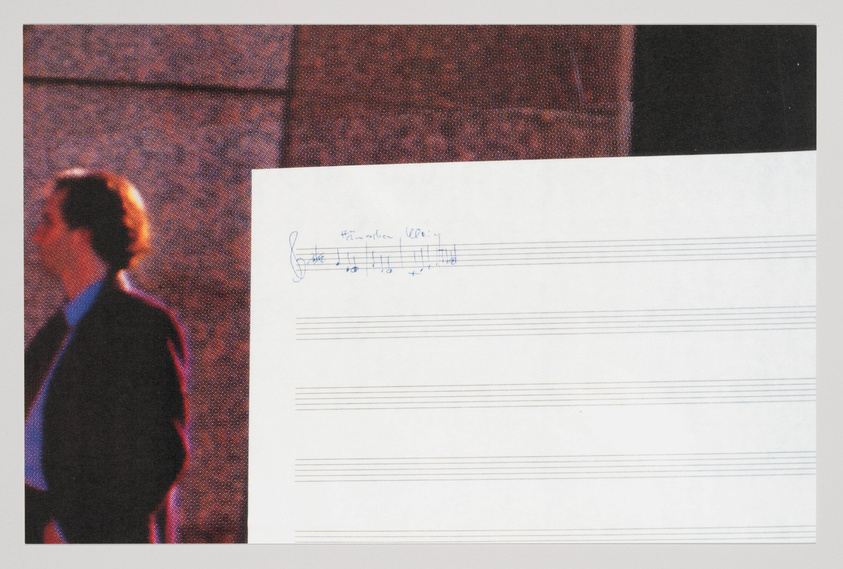 A blurred image of a person in profile walking past a textured wall on the left side, with a piece of paper featuring musical notation and handwritten annotations on the right side. The paper is overlaid on the bottom half of the image.