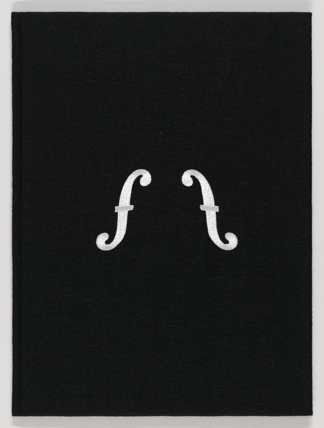 A black textile piece with two white, stylized letter Fs facing each other, creating a symmetrical design.