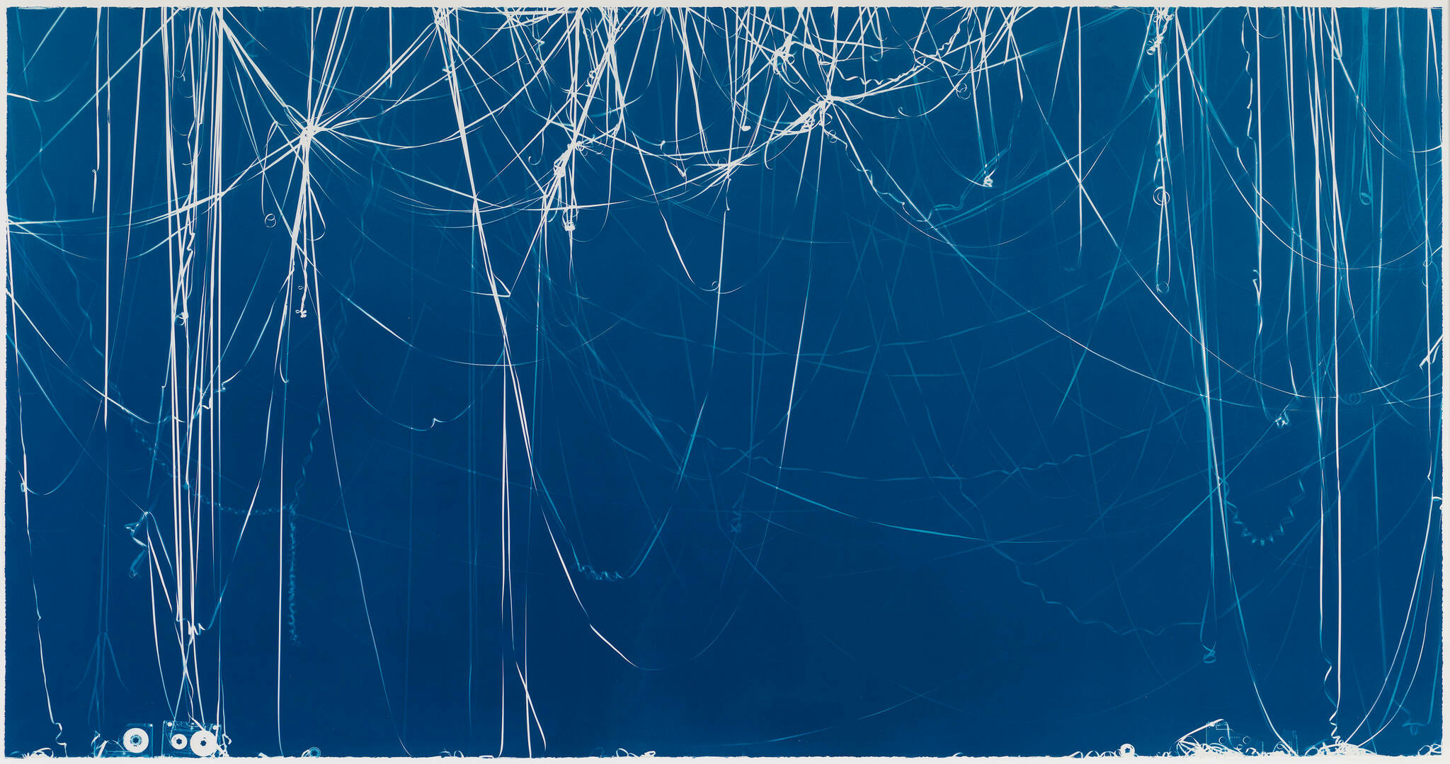 A wide-angle view of a chaotic network of white lines and scratches on a deep blue background, resembling an abstract expressionist painting or a heavily scratched surface.