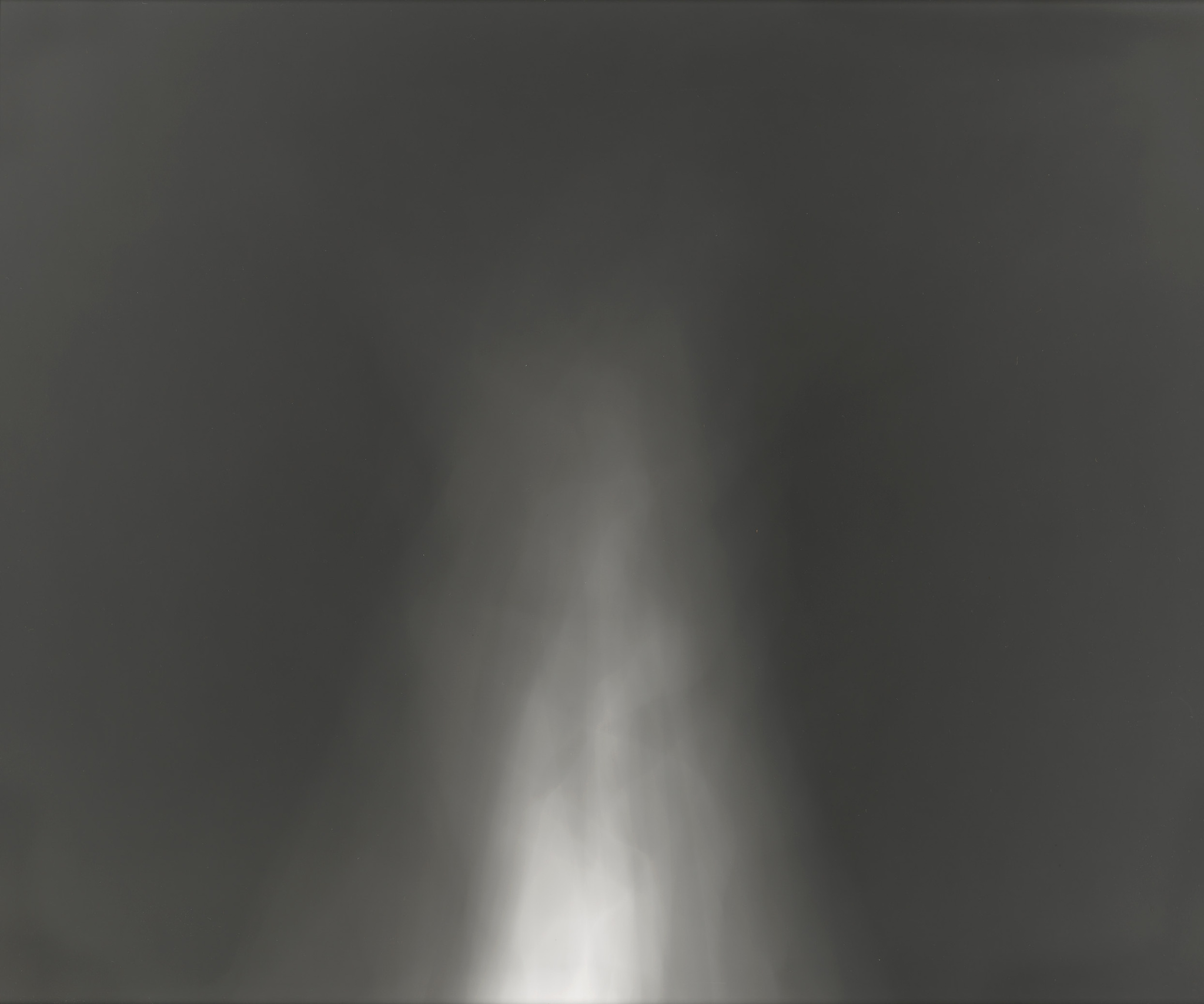 A grayscale abstract image with a bright white vertical light beam in the center against a dark, shadowy background with various shades of gray.