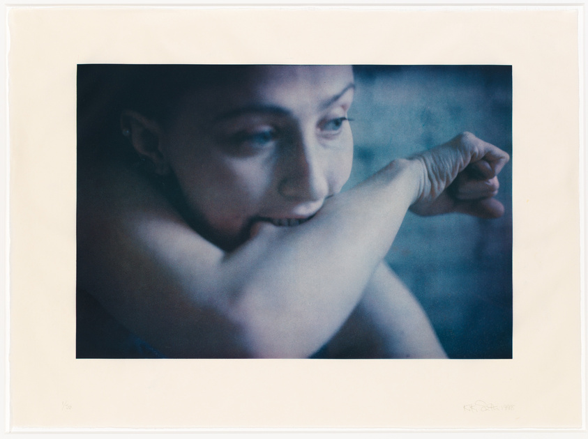 A contemplative woman resting her chin on her crossed arms, with a soft, focused expression.