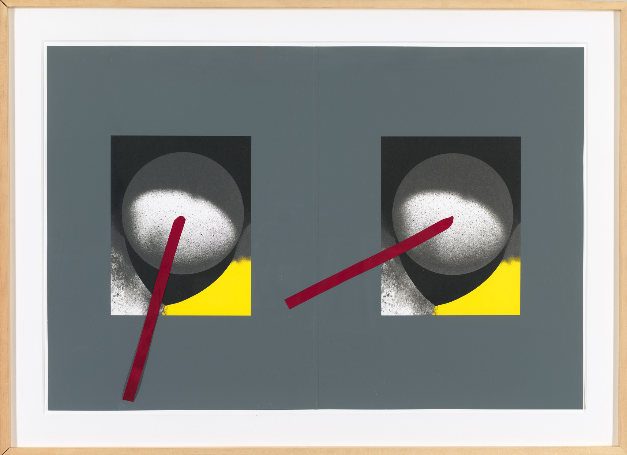 A framed artwork featuring a symmetrical composition with two abstract forms on a grey background. Each form consists of a black circle with a white speckled pattern inside, intersected by a diagonal red line, and a yellow block at the bottom corner. The piece is displayed against a white mat within a light wooden frame.