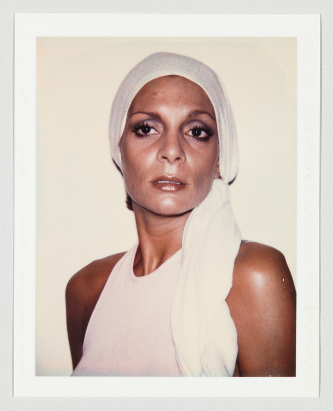 Woman wearing a white headscarf and sleeveless top, looking directly forward with a neutral expression.