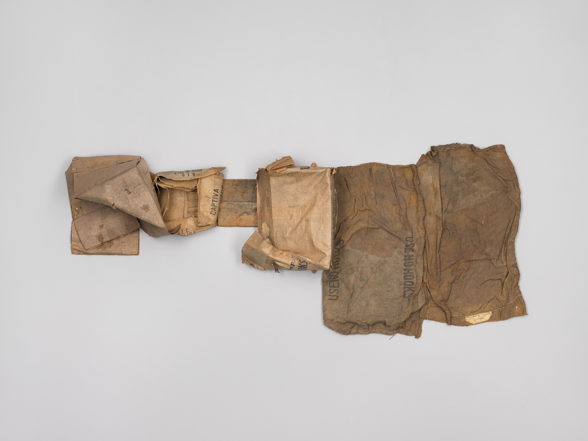 A weathered and crumpled brown paper bag with faded text, unfolded and displayed against a white background.