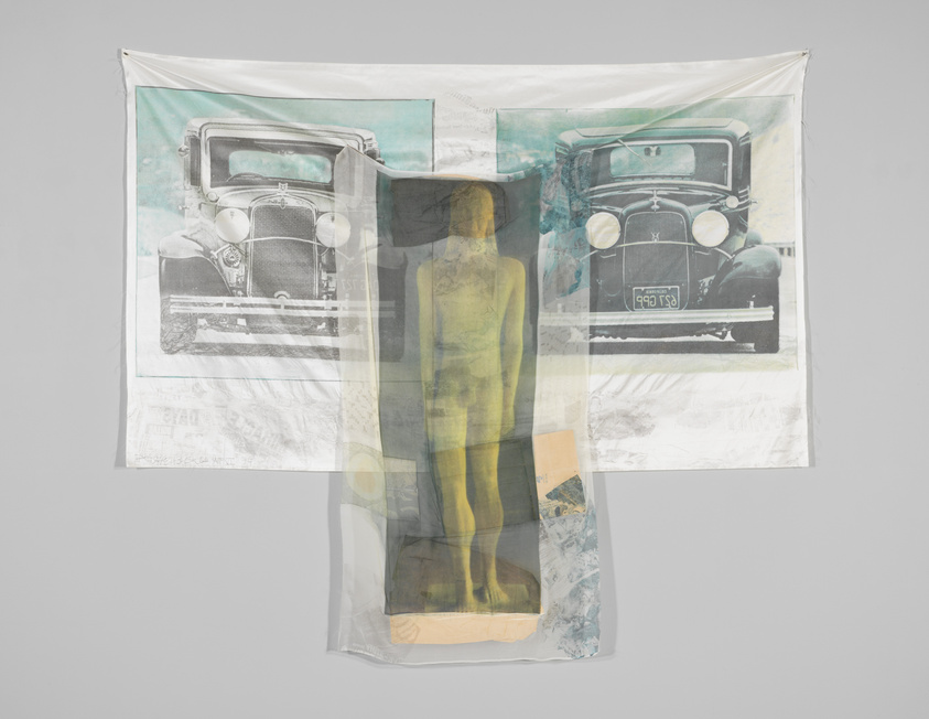 A translucent fabric with a vintage car printed on it is hanging against a light background. The car is split in the middle, with each half printed on separate panels of the fabric. The fabric appears slightly wrinkled and has a ghostly, ethereal quality.