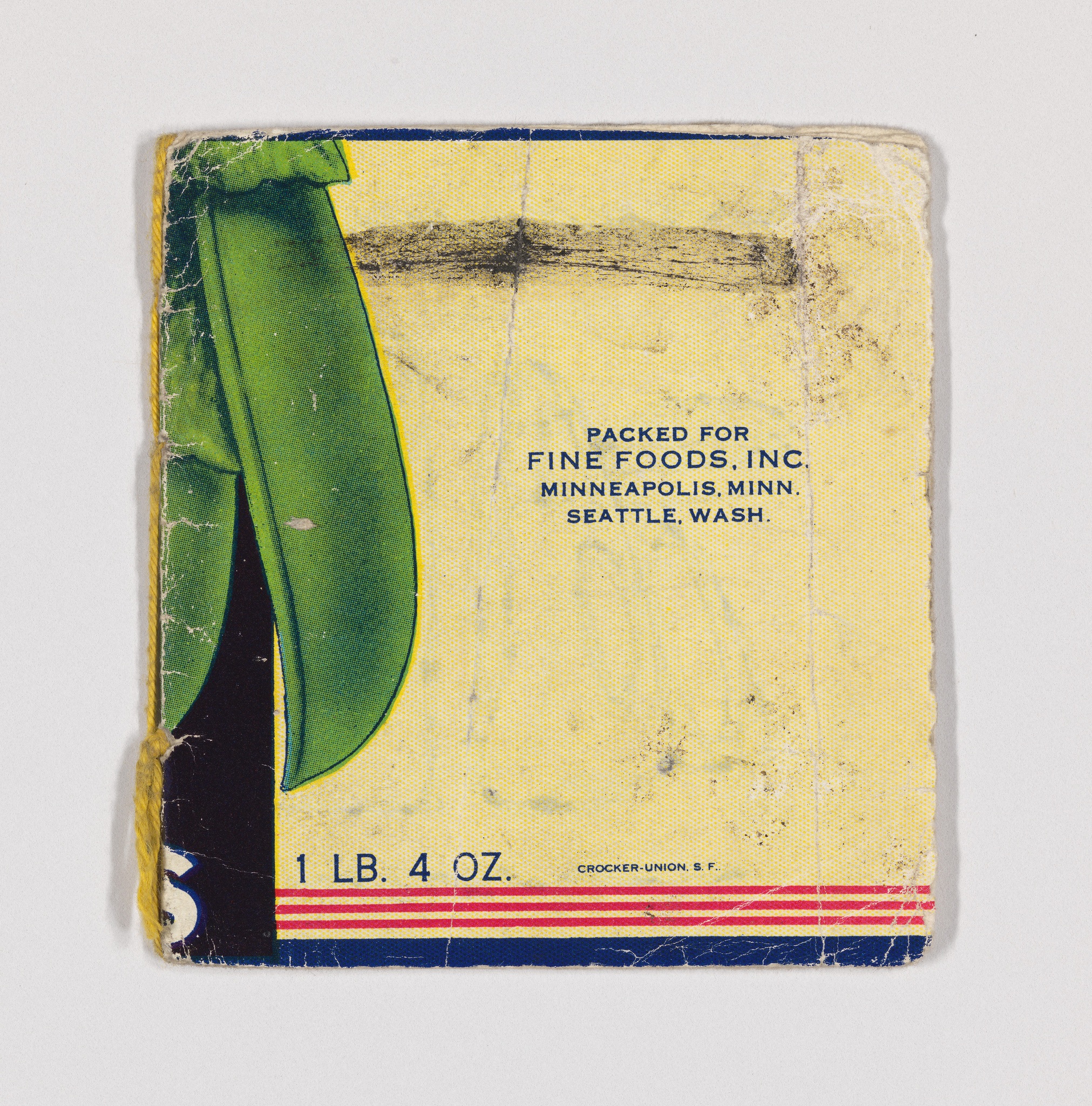 A worn and aged label with partial imagery of a green vegetable, possibly a pea pod, with text indicating it was packed for Fine Foods, Inc. in Minneapolis, Minn., and Seattle, Wash., with a weight note of 1 LB. 4 OZ. The label shows signs of wear and tear, with frayed edges and discoloration.