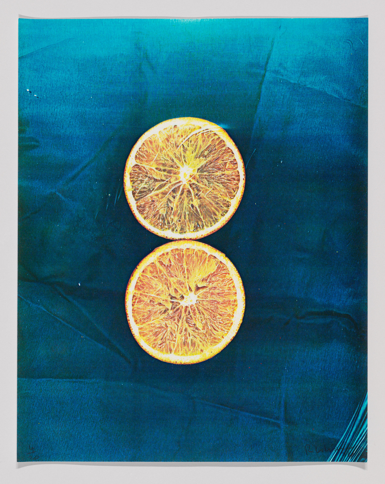 Two orange slices on a textured blue background.