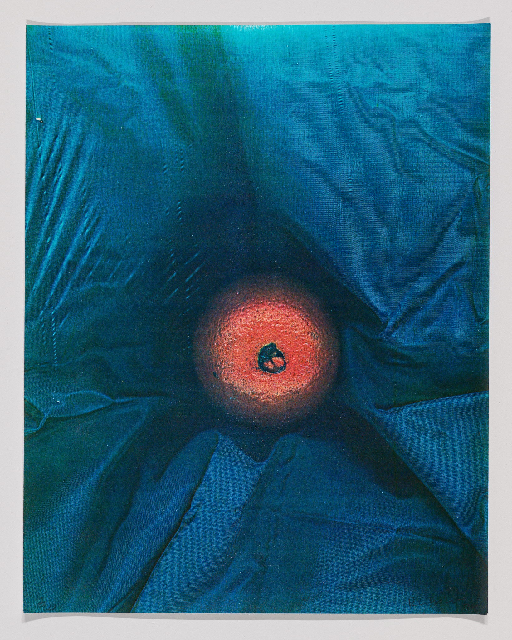 Artwork depicting a red circular form with a green center on a textured blue background, resembling an eye.