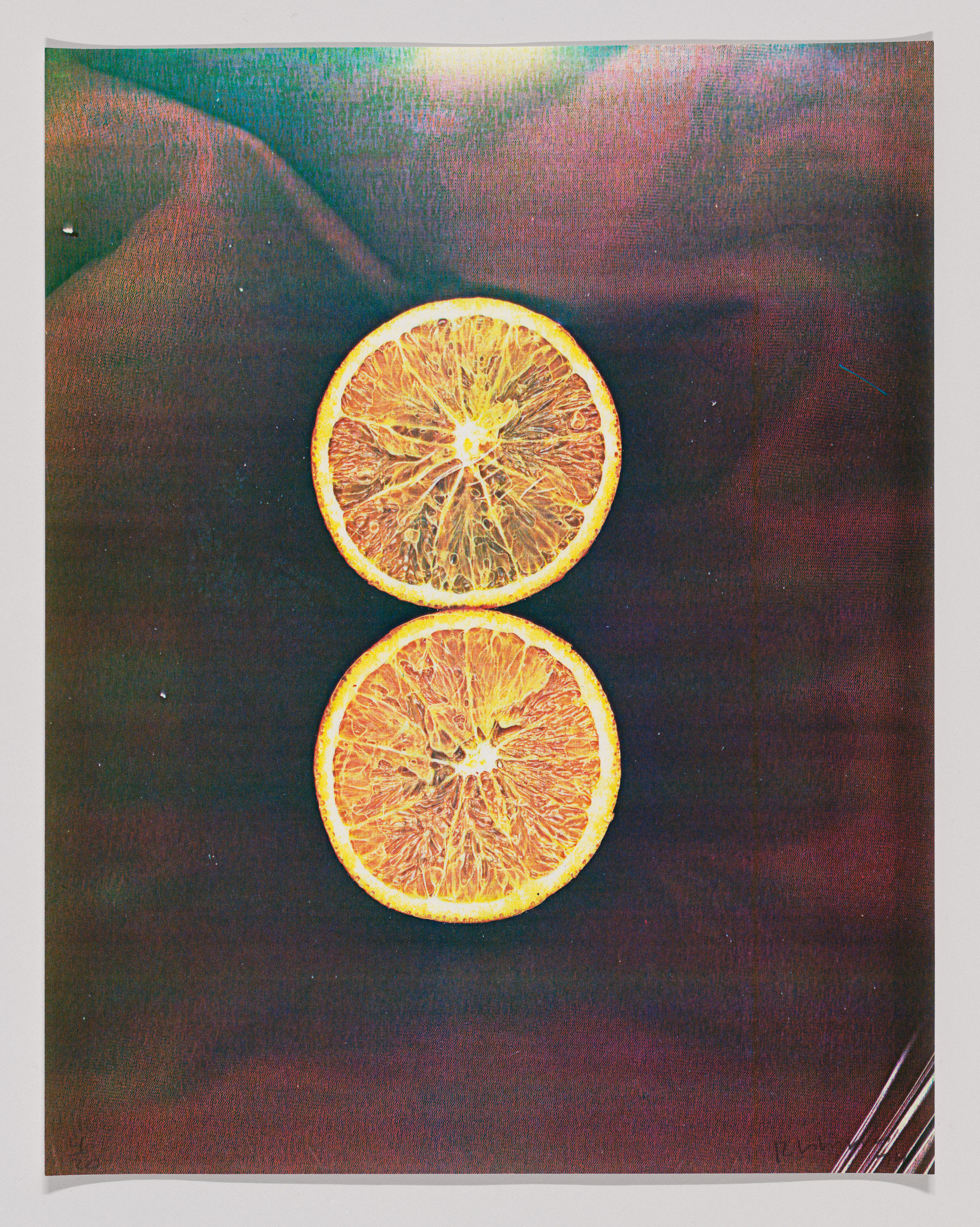 Two orange slices on a dark textured background with a light flare on the upper slice.