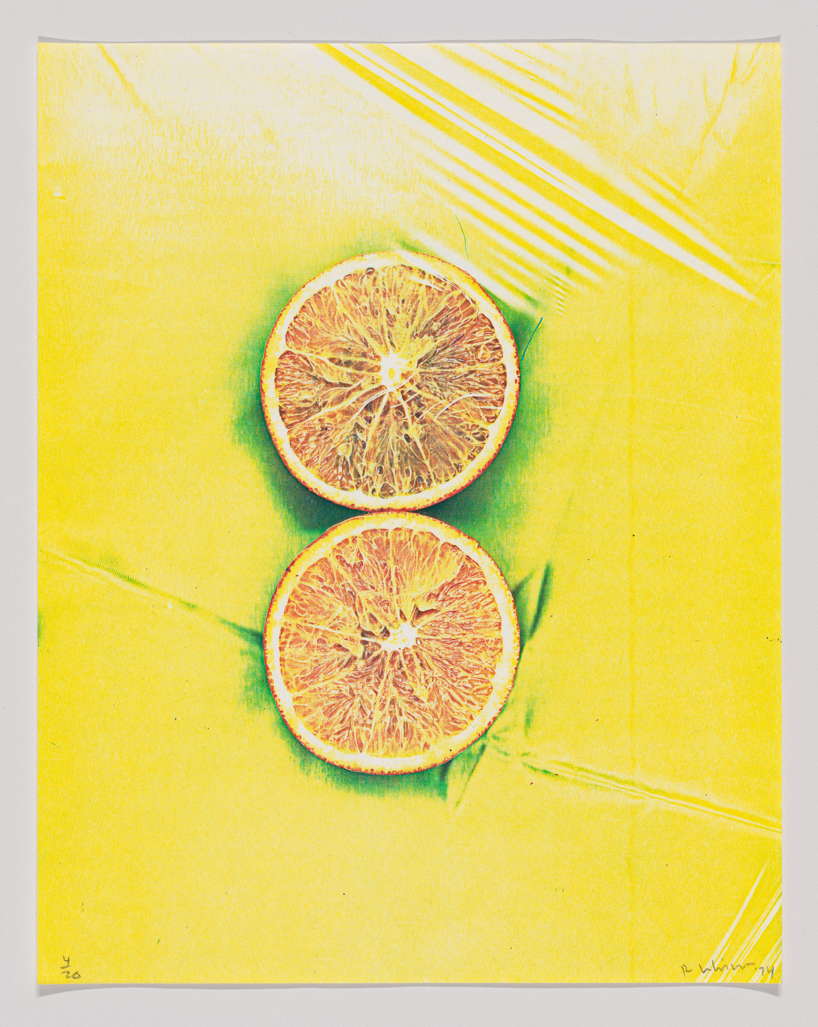Two orange slices on a yellow background with a high-contrast, color-inverted effect.