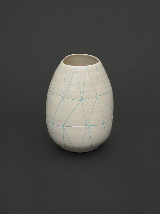 A ceramic vase with a smooth, off-white surface and a pattern of light blue intersecting lines creating a geometric design, displayed against a dark background.