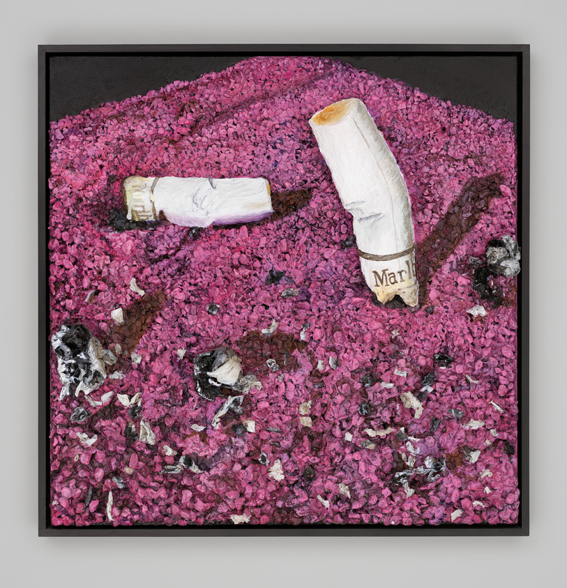 Close-up of two Marlboro cigarette butts plunged into pink ash