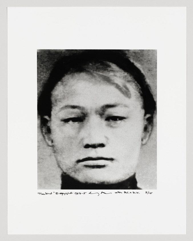 Black and white portrait of a person with a neutral expression, cropped to show only the face and part of the neck. The image is grainy and appears to be an enlargement of a smaller photograph. Below the image, there is handwritten text and a signature, indicating that this is a numbered piece of artwork.