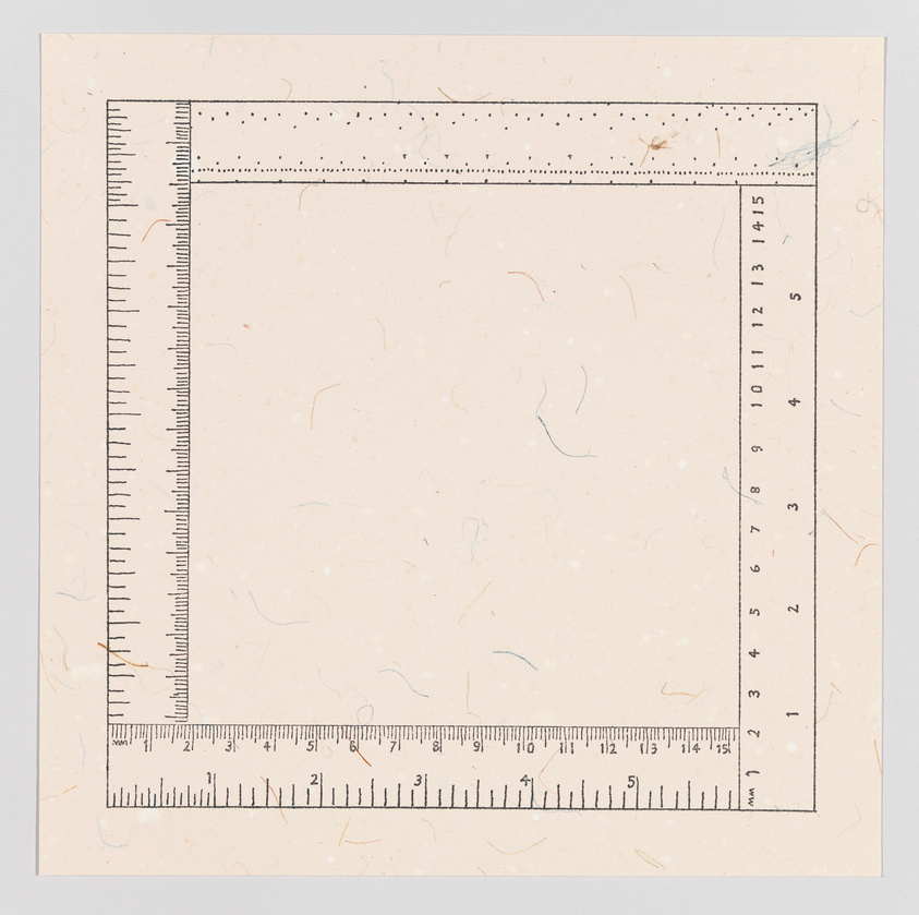 A square piece of paper with a ruler border printed along two adjacent edges, showing measurements in centimeters and millimeters. The paper has a textured appearance with small, colored fibers throughout.