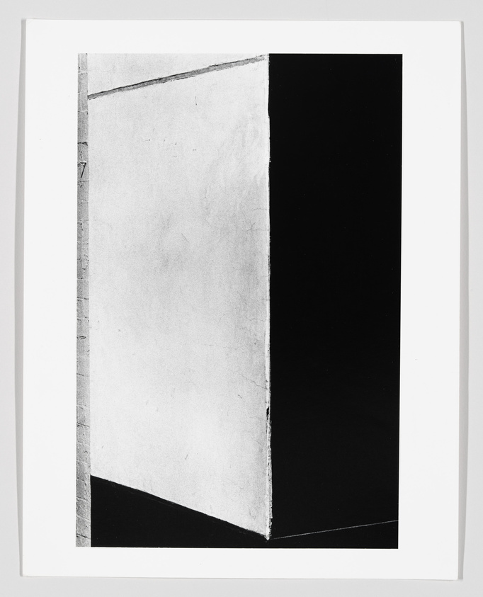Black and white abstract image with a sharp vertical division; left side is light gray, right side is black.