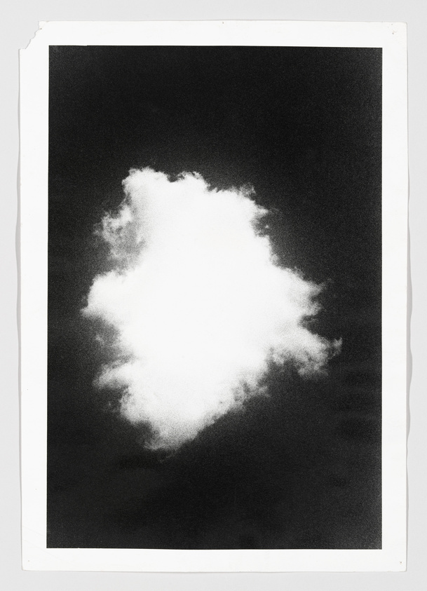 A monochrome image featuring a single, fluffy white cloud centered on a black background, with a white border framing the picture.