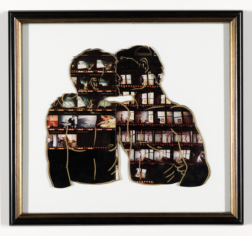 Framed artwork featuring a silhouette of two people filled with a collage of photographic film strips, displayed against a white background.