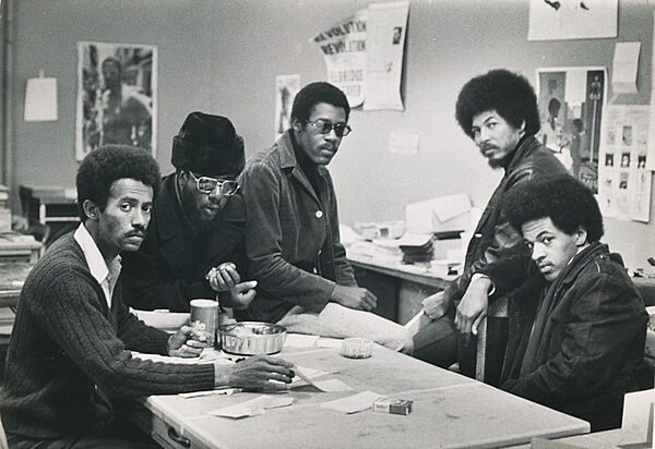 Five men gathered around a table.