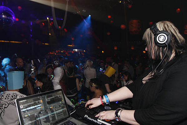 DJ booth and revelers in front.