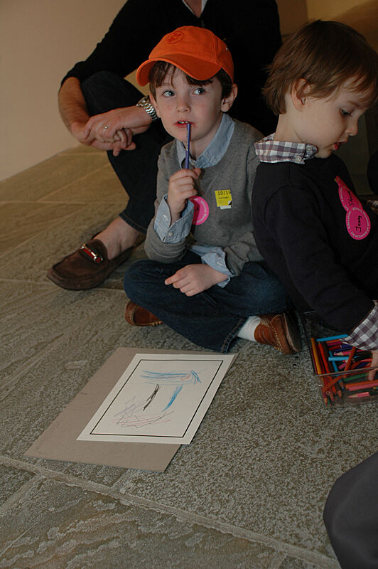 Child with pencil in hand and paper in front.