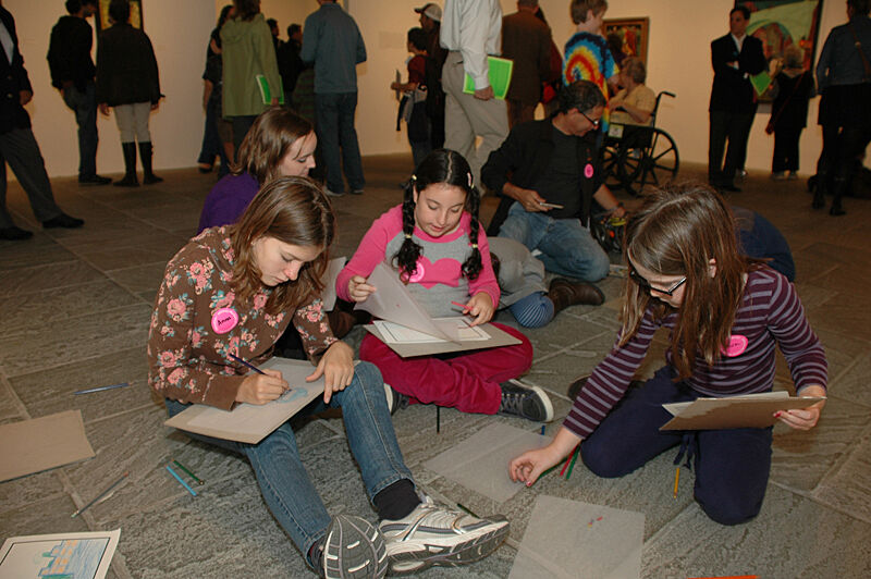 Children drawing on the ground together.