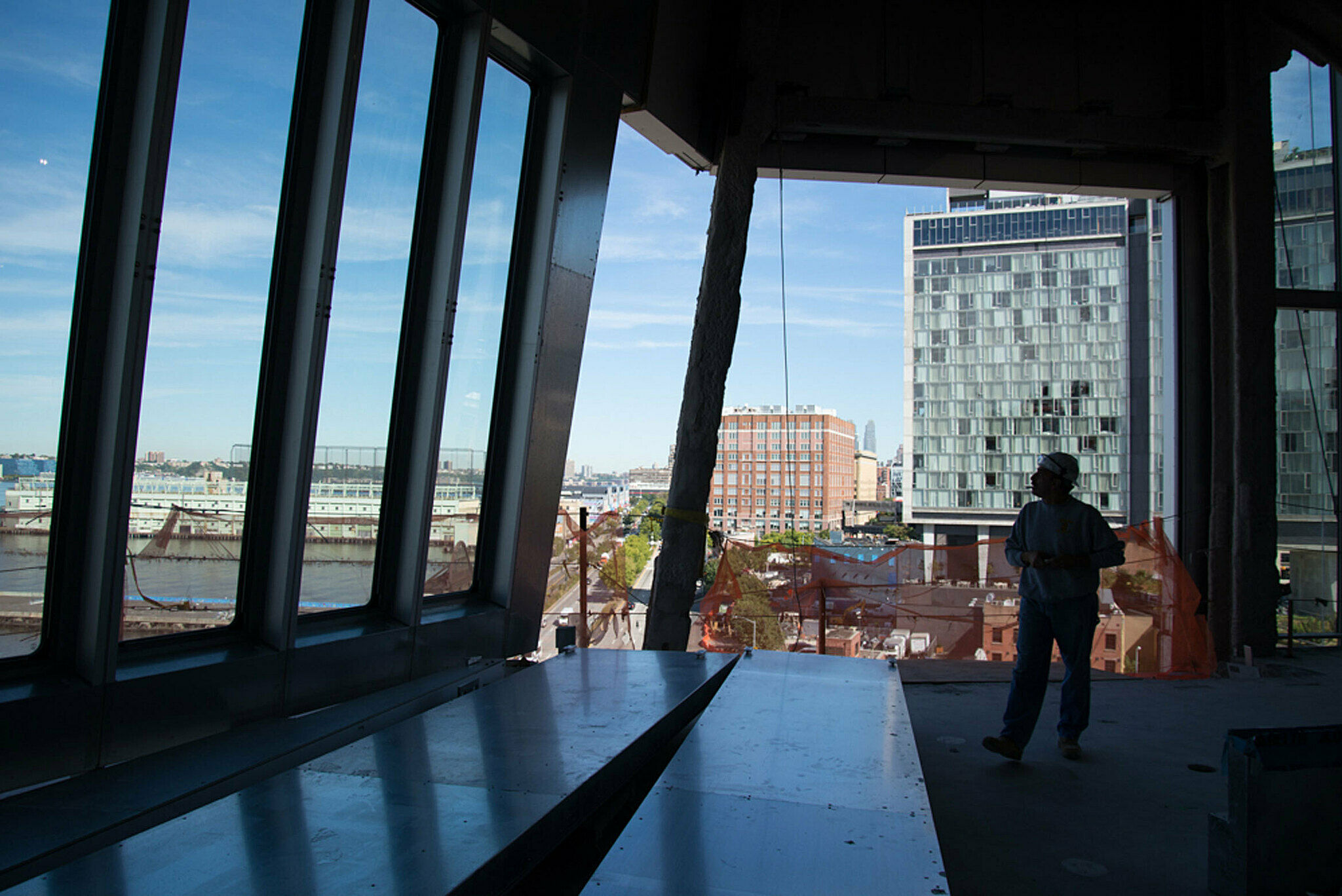 Man looking out on Hudson from large windows.