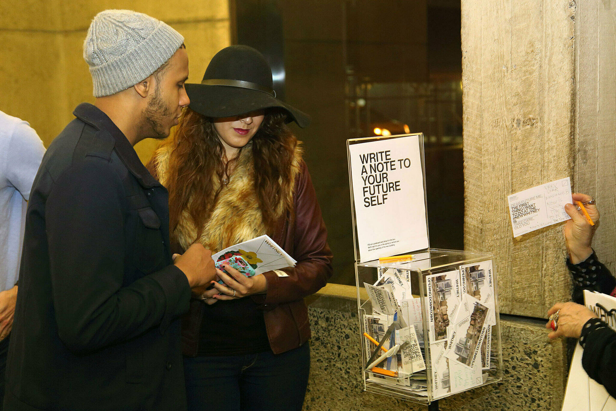 Visitors putting cards in clear box.