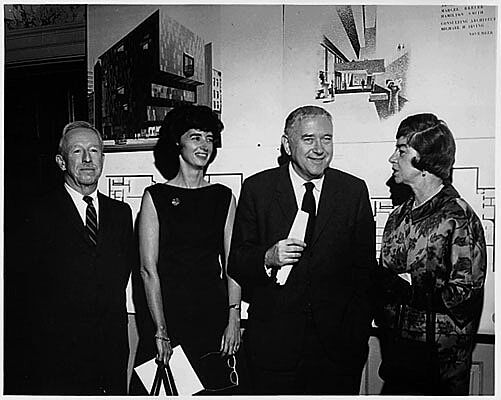 Four people in front of plans.