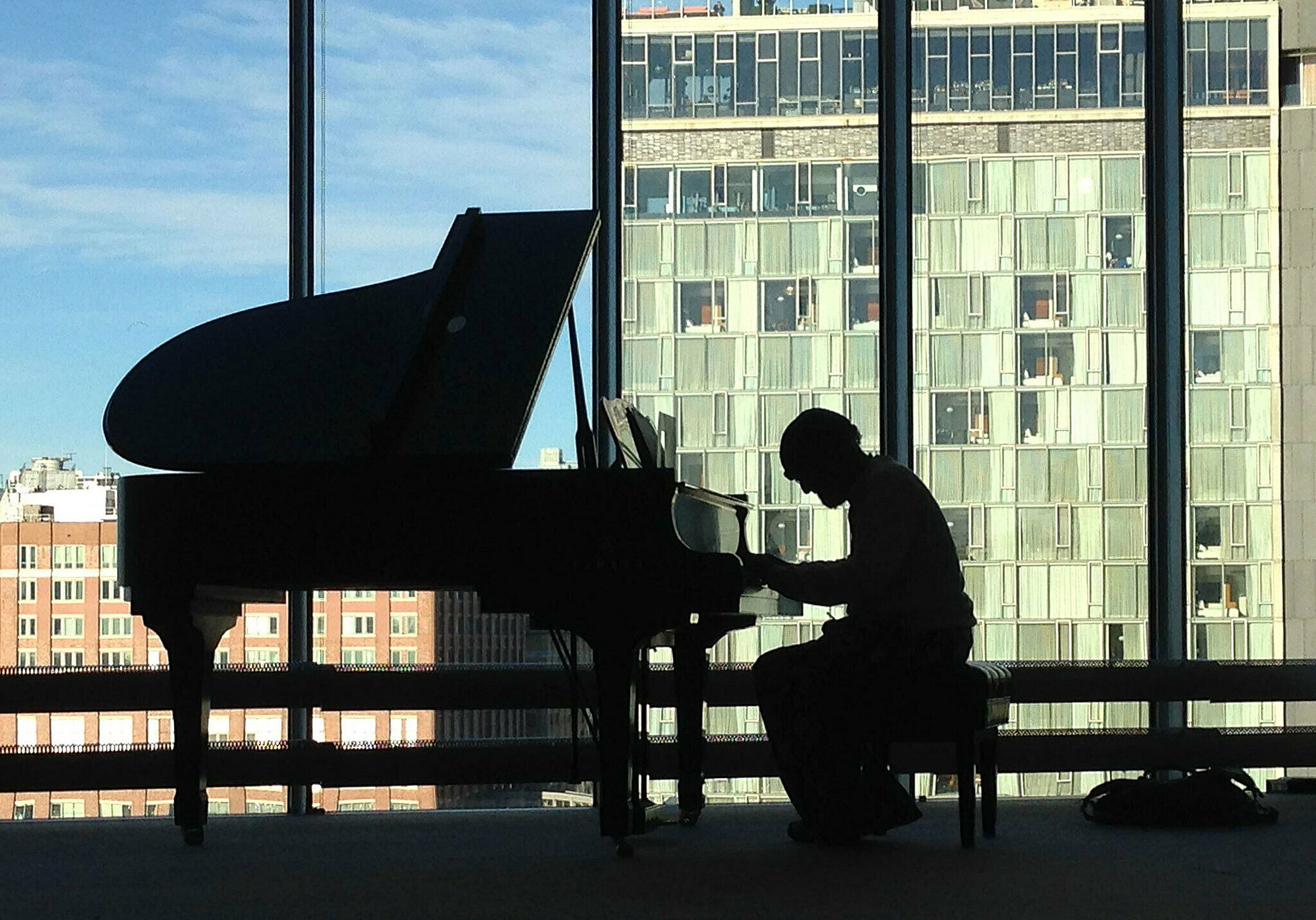Cecil Taylor sitting at a baby grand piano.