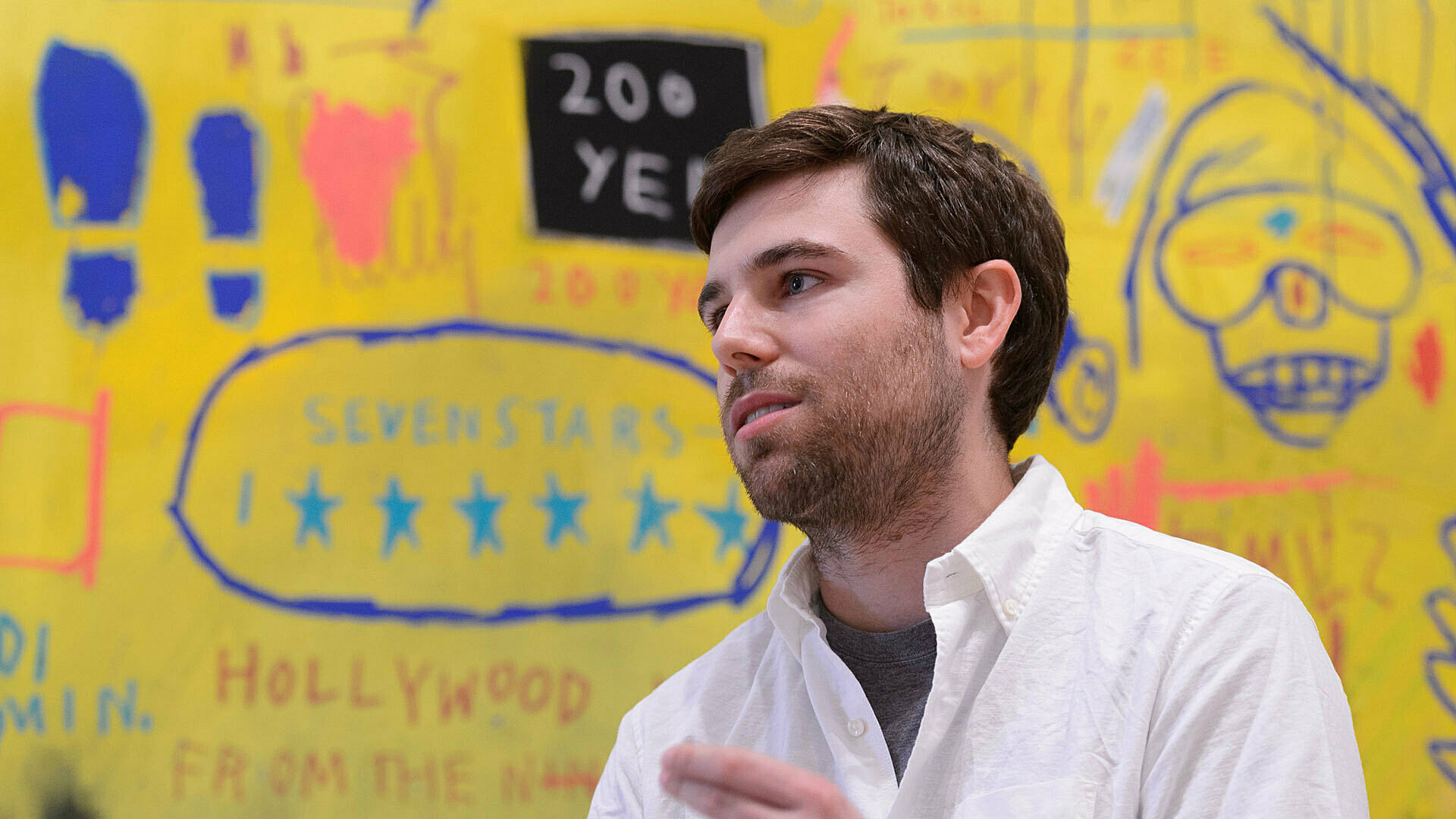 Man standing in front of Basquiat painting.