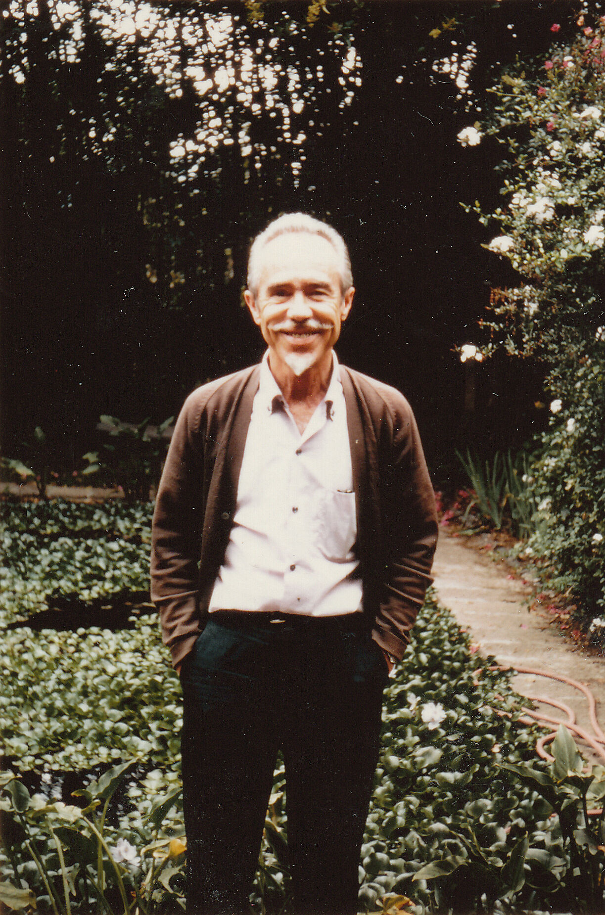 The composer Conlon Nancarrow wearing a sweater in his garden.