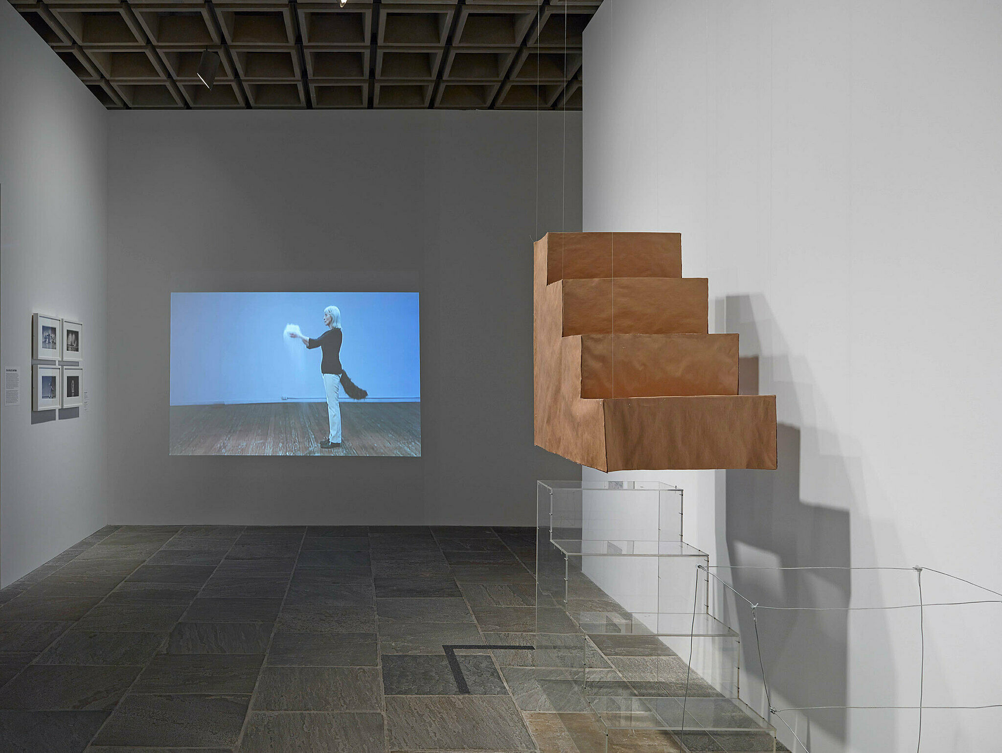 Art installation with a video and block of wooden stairs.