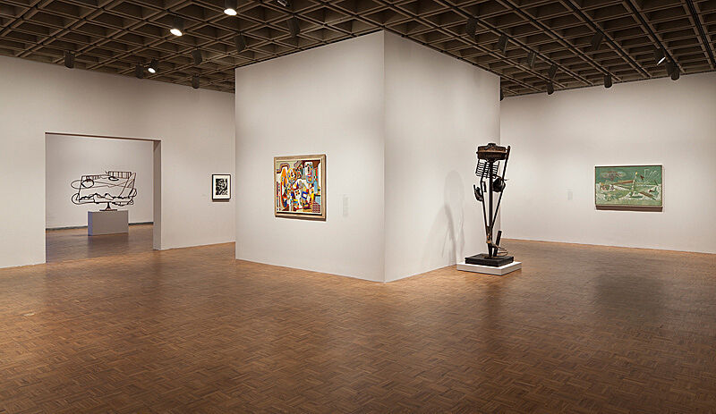 An installation view in a gallery with wooden floors and white walls.