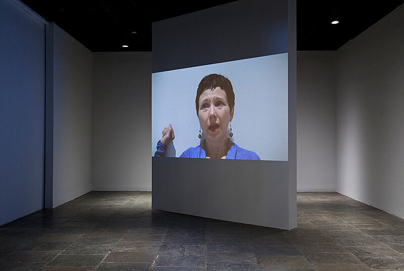 A video installation with a screen featuring a woman's face.