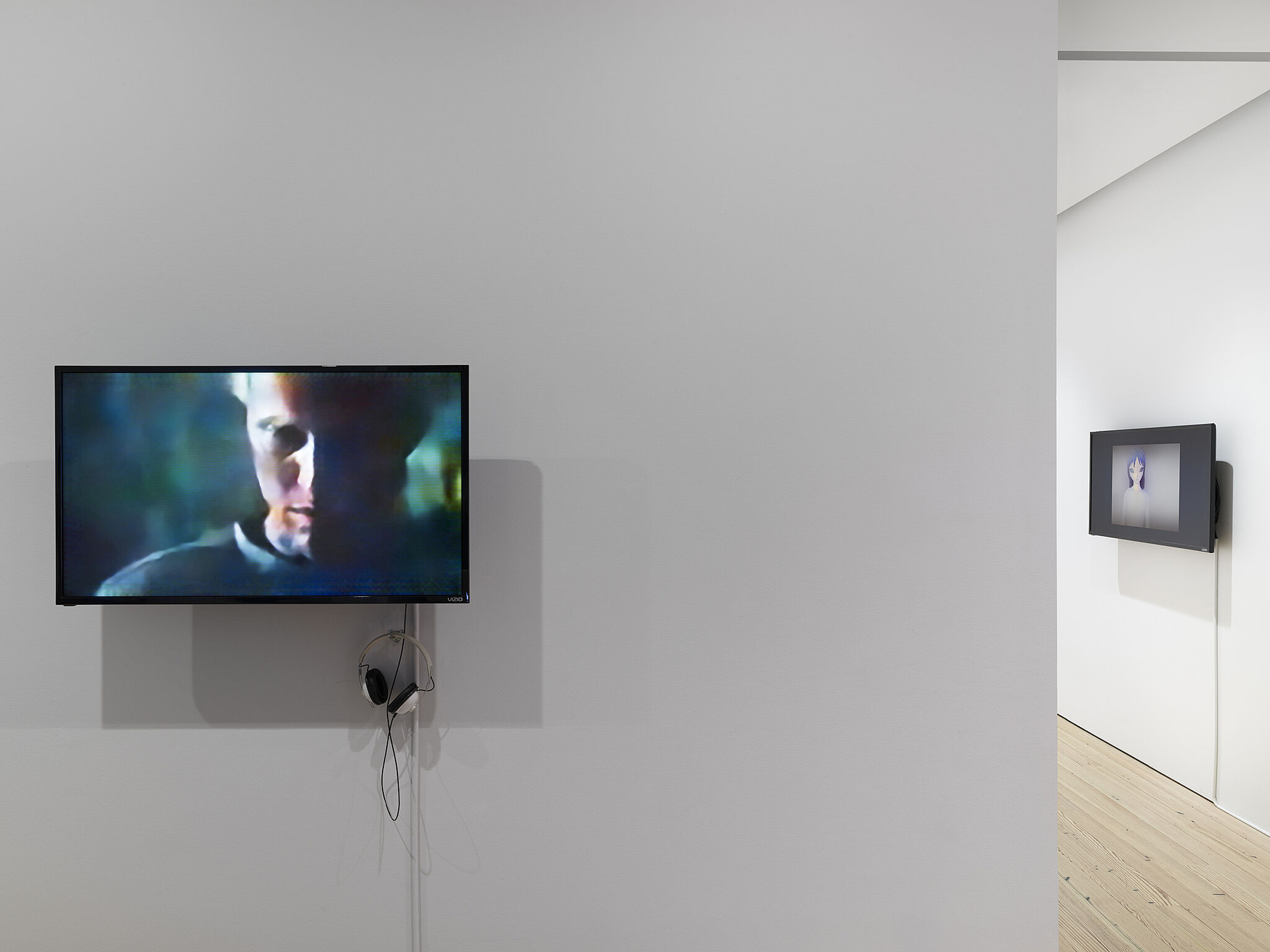 Two video screens displaying faces at the Dreamlands exhibit.